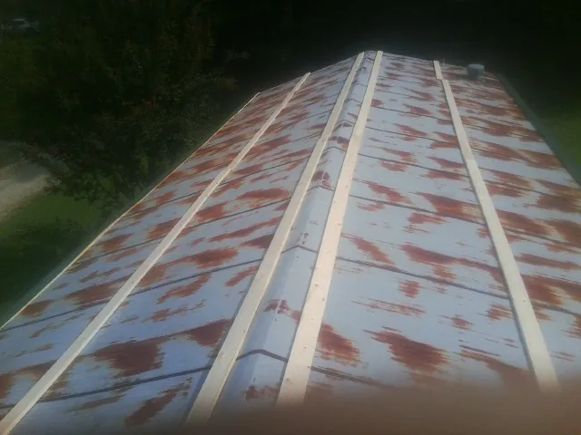 Rusted metal roof panels with new wood purlins before replacement — Storm Damage Roof Repair in Americus by Roofing Brothers