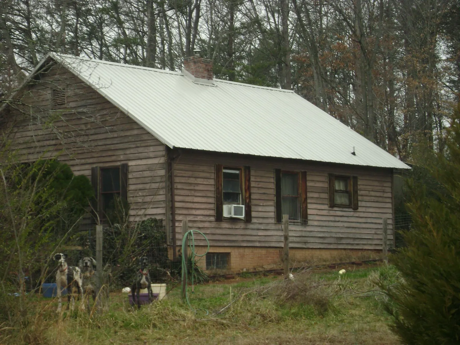 White metal roof on an old wood sided farmhouse, from a Metal Roof Installation job in Americus